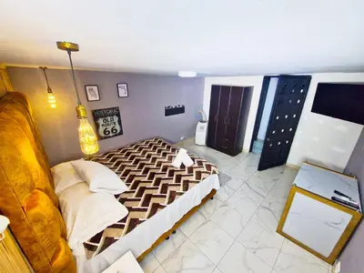 a bedroom with a bed and a couch in it at Urban 8 Bedrooms Apartment at Poblado in Medellín