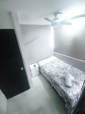 a small bedroom with a bed and a ceiling fan at Urban 8 Bedrooms Apartment at Poblado in Medellín
