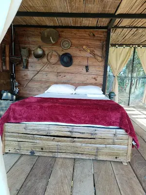 a bedroom with a large bed with a red blanket at Cabaña la Antiguita in San Luis