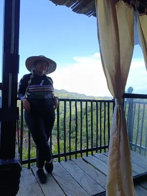 a woman wearing a hat standing on a balcony at Cabaña la Antiguita in San Luis