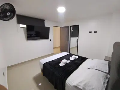 a bedroom with a bed with two white towels on it at Format one in Medellín