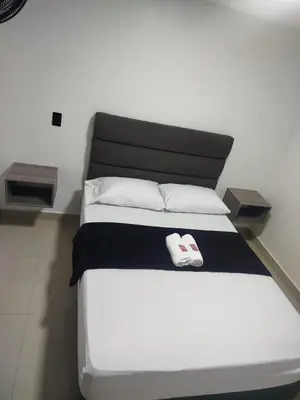 a bed in a room with two towels on it at Format one in Medellín