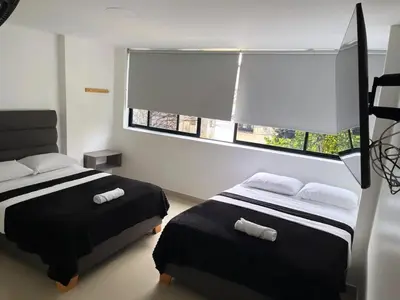 two beds in a room with a large window at Format one in Medellín