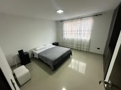 a white bedroom with a bed and a window at Acogedor apartamento en Laureles in Medellín