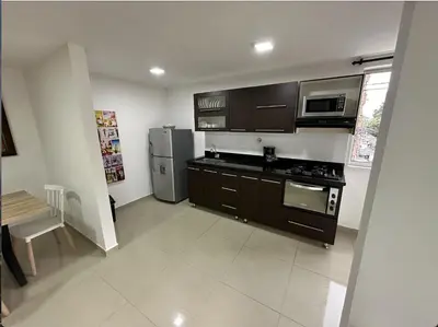 a kitchen with brown cabinets and a stainless steel refrigerator at Acogedor apartamento en Laureles in Medellín