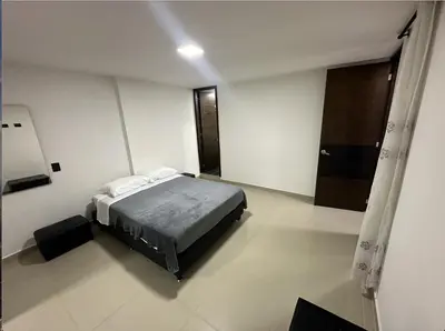 a bedroom with a bed in a white room at Acogedor apartamento en Laureles in Medellín