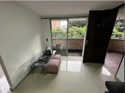 a glass table and a pink chair in a room at Acogedor apartamento en Laureles in Medellín