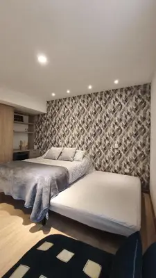 a bedroom with two beds and a wall at Hermoso apartaestudio Zona Rosa de Milan in Manizales