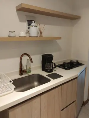 a kitchen counter with a sink and a stove at Hermoso apartaestudio Zona Rosa de Milan in Manizales