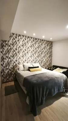 a bedroom with a large bed with a patterned wall at Hermoso apartaestudio Zona Rosa de Milan in Manizales