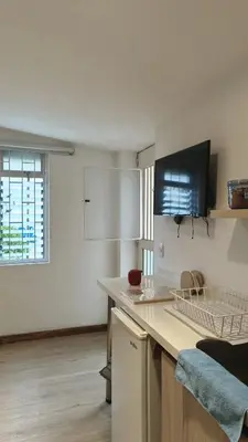a white kitchen with a counter and a window at Hermoso apartaestudio Zona Rosa de Milan in Manizales