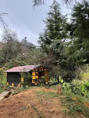 a small building in the middle of a field at Cabañas Tahamí con jacuzzi cerca al Aeropuerto in Guarne