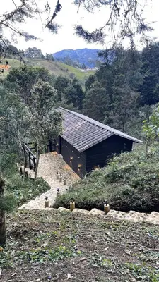 a building in the middle of a field with trees at Cabañas Tahamí con jacuzzi cerca al Aeropuerto in Guarne