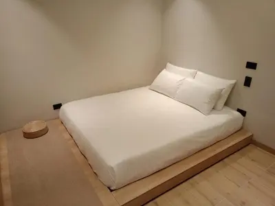 a bed with white sheets and pillows in a room at Casa Tokyo Manila By Xcay Home in Medellín
