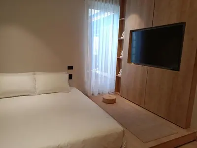 a bedroom with a bed and a flat screen tv at Casa Tokyo Manila By Xcay Home in Medellín