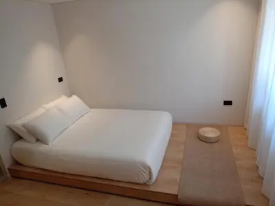 a bedroom with a white bed and a wooden floor at Casa Tokyo Manila By Xcay Home in Medellín