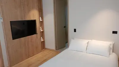 a bedroom with a bed with a flat screen tv at Casa Tokyo Manila By Xcay Home in Medellín