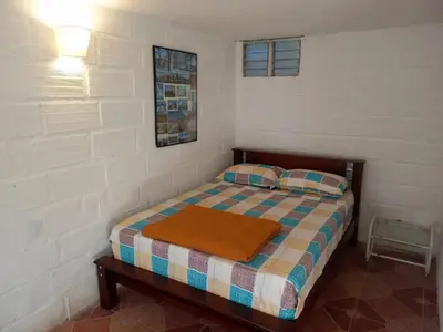 a small bedroom with a bed and a table at Casa Finca Minas in Estación Angelópolis