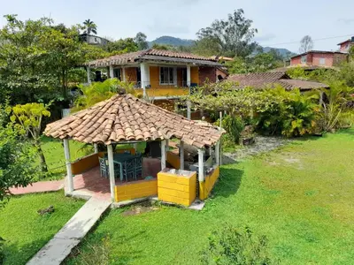 a small yellow house with a thatched roof at Casa Finca Minas in Estación Angelópolis