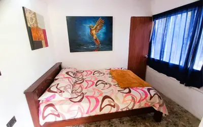 a bedroom with a bed with a bird on the wall at Casa Finca Minas in Estación Angelópolis