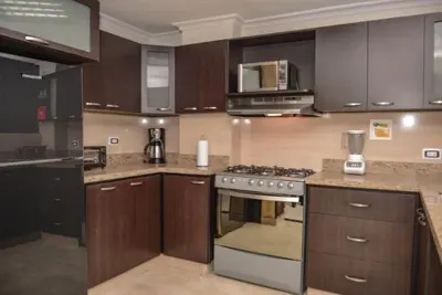 a kitchen with wooden cabinets and a stove top oven at Poblado medellin cll8 101 in Medellín