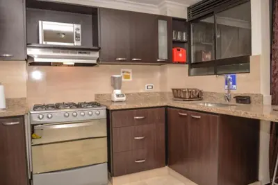 a kitchen with wooden cabinets and a stove top oven at Poblado medellin cll8 101 in Medellín