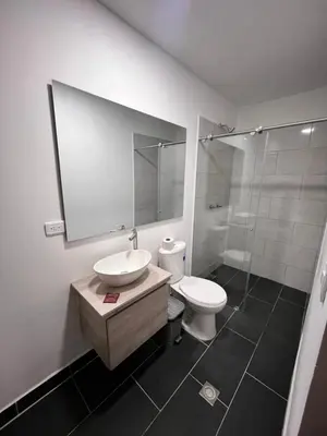a bathroom with a sink and a toilet and a mirror at Hotel Gallery By 70 in Medellín