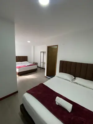 a bedroom with two beds and a large bed sidx sidx sidx at Hotel Gallery By 70 in Medellín