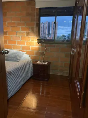 a bedroom with a bed and a lamp on a night stand at Habitacion confortable 1 persona in Medellín