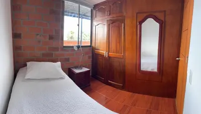 a bedroom with a bed and a brick wall at Habitacion confortable 1 persona in Medellín