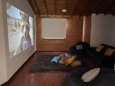 a person laying on a floor in a room with a couch at Kyra Sol Cinehome El Carmen Carmen de Viboral Cerca al Centro in Carmen de Viboral
