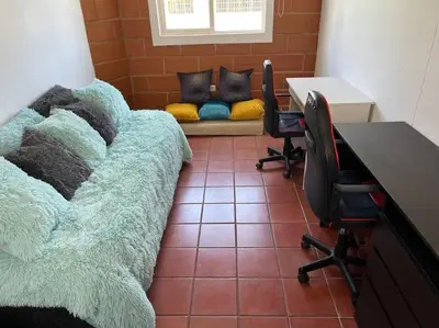a room with a desk and chairs and a couch at Kyra Sol Cinehome El Carmen Carmen de Viboral Cerca al Centro in Carmen de Viboral