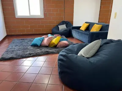 a room with two couches and pillows on the floor at Kyra Sol Cinehome El Carmen Carmen de Viboral Cerca al Centro in Carmen de Viboral