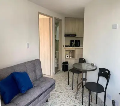 a living room with a couch and a table at Loft Céntrico en Medellín Plaza Mayor y Parking 309 in Medellín