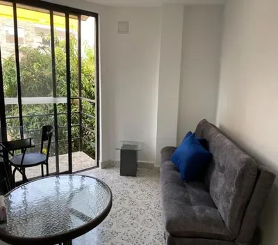 a living room with a couch and a glass table at Loft Céntrico en Medellín Plaza Mayor y Parking 309 in Medellín