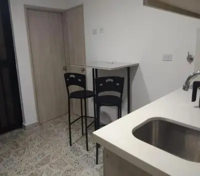 a kitchen with two black chairs and a sink at Céntrico Familiar Vive y disfruta Medellín 107 in Medellín