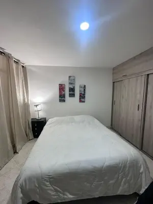 a bedroom with a white bed and two paintings on the wall at Habitación en apto duplex baño compartido, piso 5 sin ascensor in Envigado