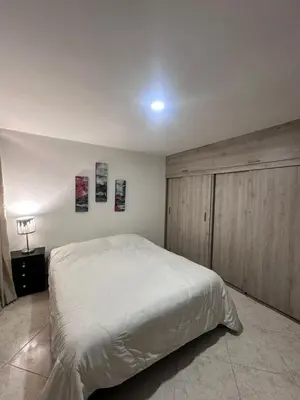a bedroom with a white bed and wooden cabinets at Habitación en apto duplex baño compartido, piso 5 sin ascensor in Envigado