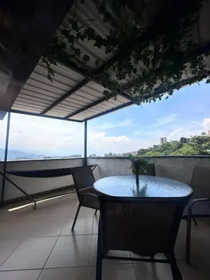 a table and chairs on a balcony with a view at Habitación en apto duplex baño compartido, piso 5 sin ascensor in Envigado