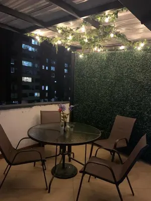 a table and chairs in a room with a green wall at Habitación en apto duplex baño compartido, piso 5 sin ascensor in Envigado