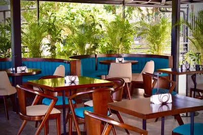 a restaurant with tables and chairs and plants at Rooca Habitat Guatape in Guatapé
