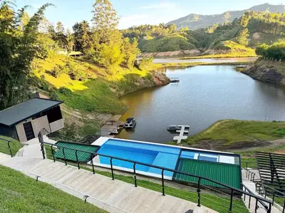 a view of a river with a house and a pool at Rooca Habitat Guatape in Guatapé