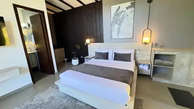 a bedroom with a large white bed in a room at Rooca Habitat Guatape in Guatapé