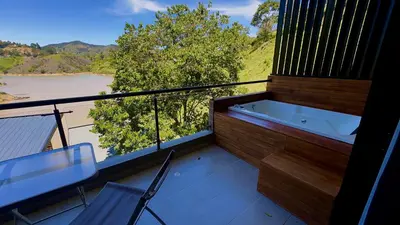 a balcony with a bath tub and a view of a river at Rooca Habitat Guatape in Guatapé