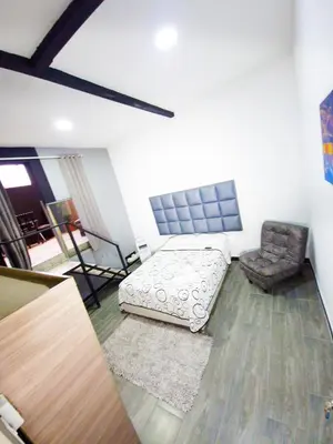a living room with a bed and a chair at Sunset Strip Suite # 301C ICON Lleras Park 301 in Medellín