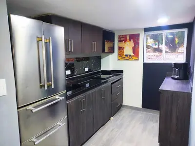 a kitchen with wooden cabinets and stainless steel appliances at Sunset Strip Suite # 301C ICON Lleras Park 301 in Medellín