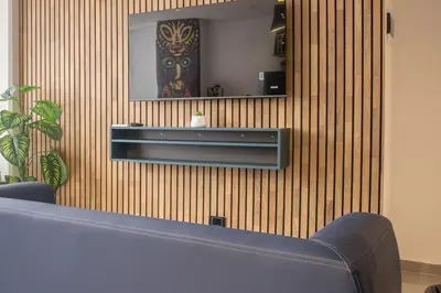 a living room with a blue couch and a mirror at Comfy Aparta-Suite Stadio Rosa Negra in Medellín