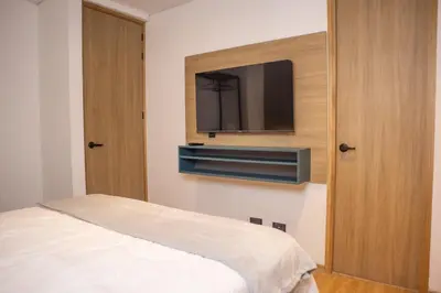 a bedroom with a bed and a flat screen tv at Comfy Aparta-Suite Stadio Rosa Negra in Medellín