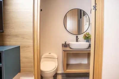 a bathroom with a toilet and a mirror at Comfy Aparta-Suite Stadio Rosa Negra in Medellín
