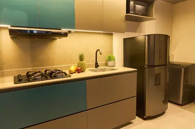 a kitchen with a stove and a refrigerator at Charming Aparta-Suite Stadio Rosa Negra Retreat in Medellín